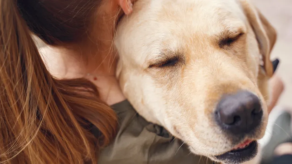 a woman hugging dog